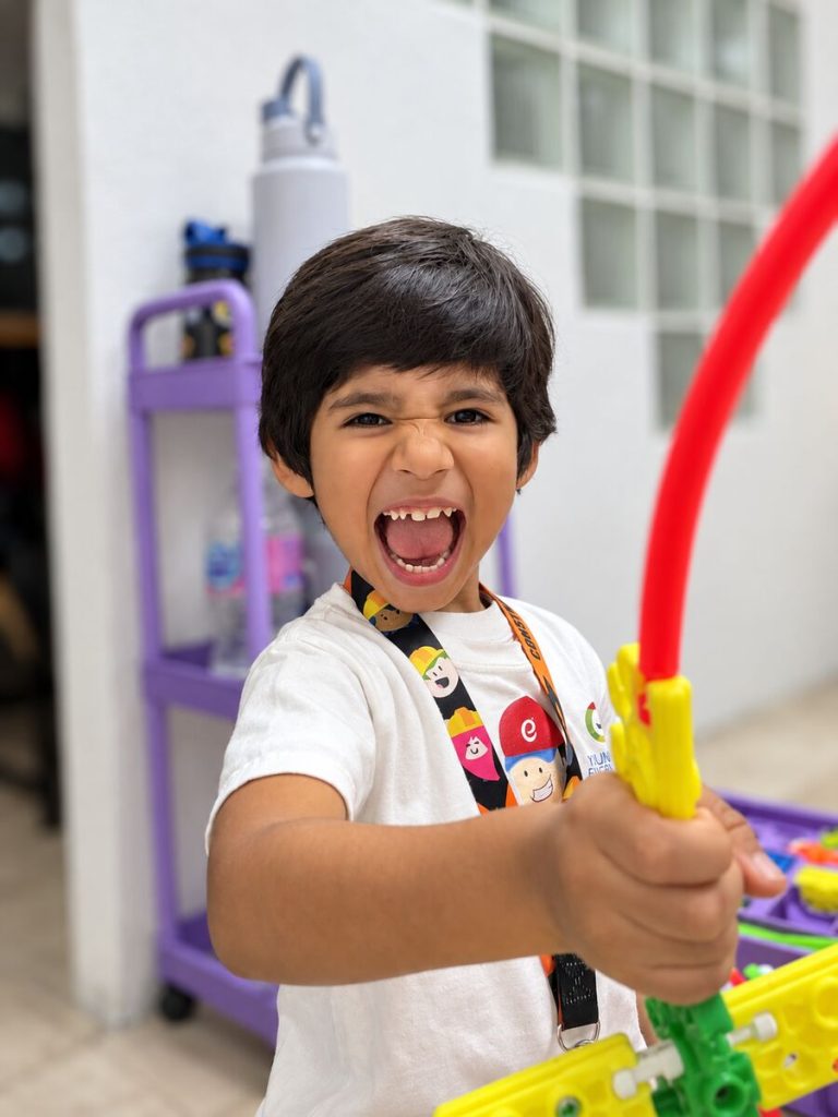 Niño sonriente muestra su construcción STEAM en Centro Educativo STEAM